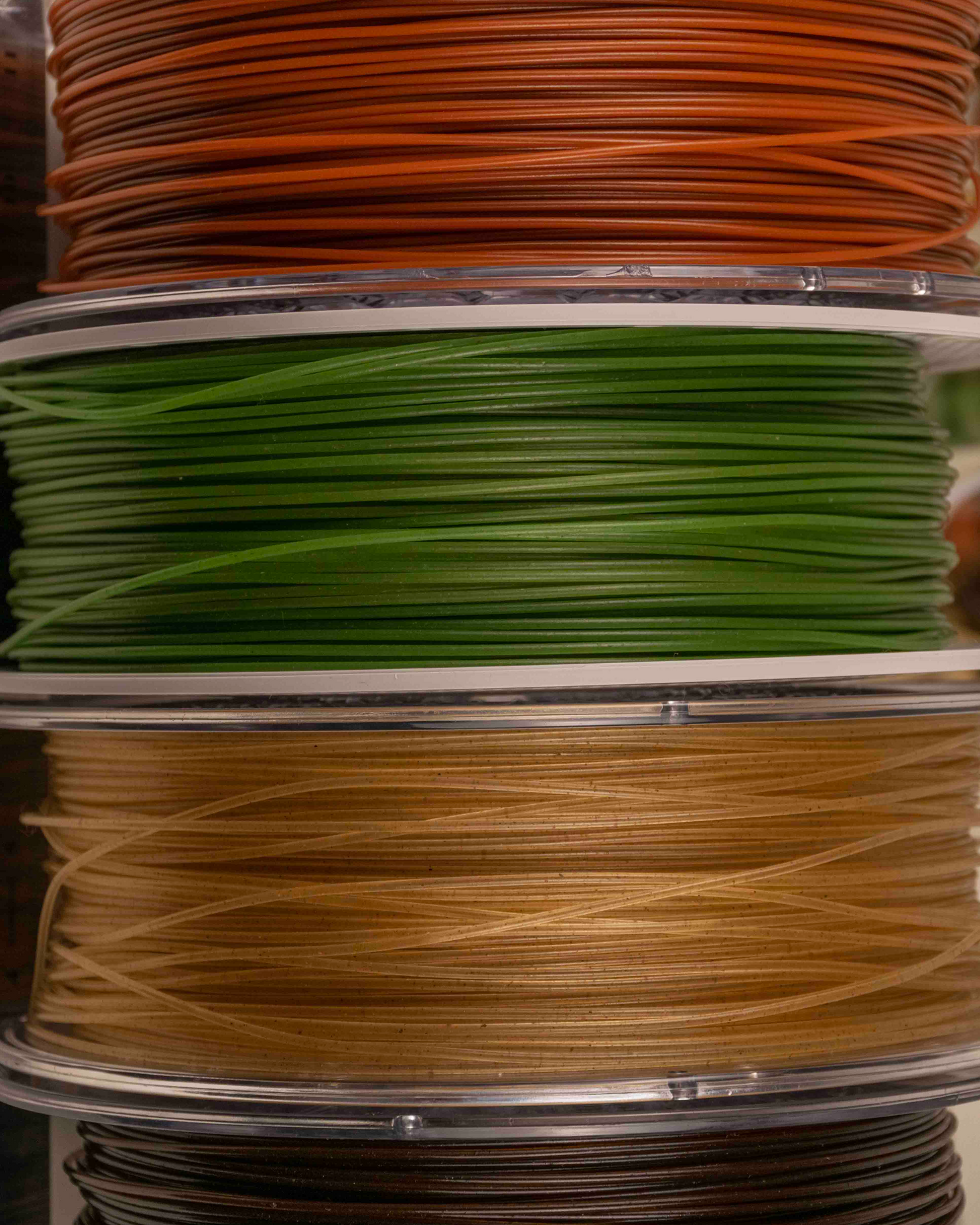 spools of filaments made of reclaimed organic materials: terracotta, hemp, wheat, coffee