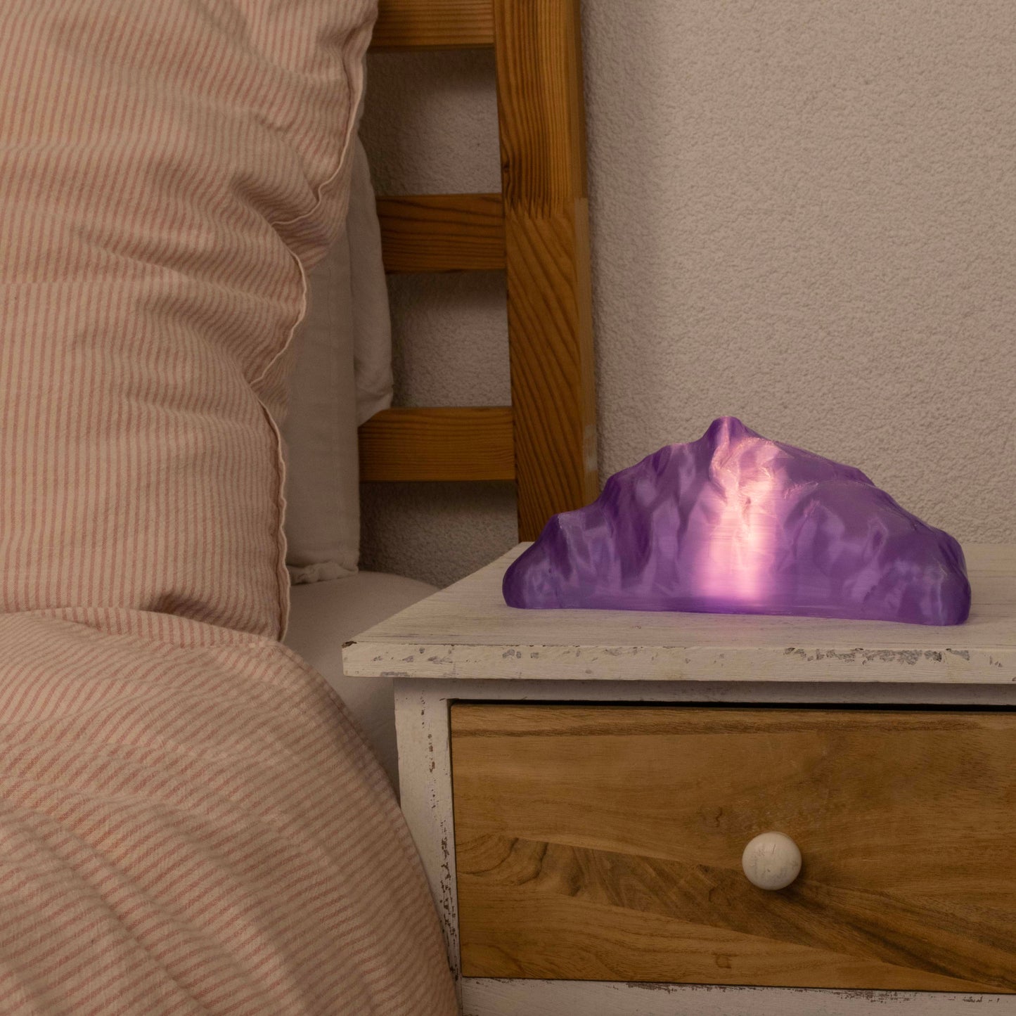Purple croissant lamp on a wooden nightstand