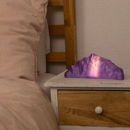 Purple croissant lamp on a wooden nightstand