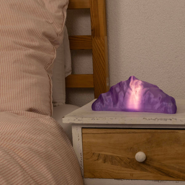 Purple croissant lamp on a wooden nightstand