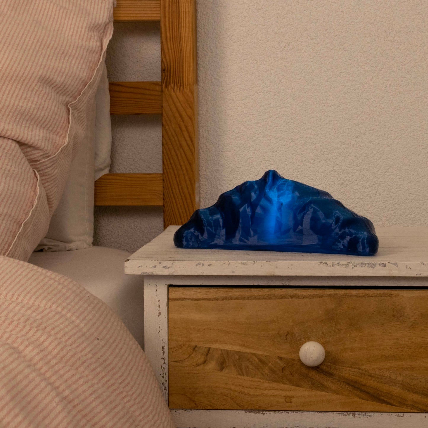 Blue croissant lamp on a wooden nightstand