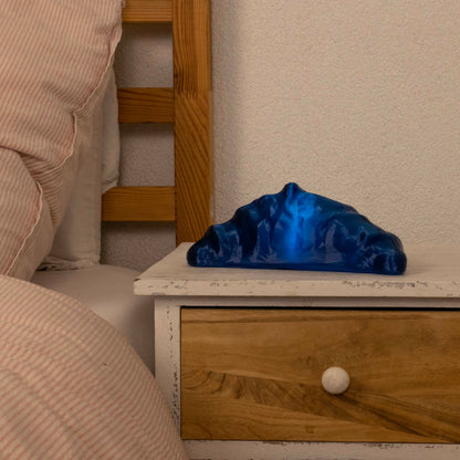 Blue croissant lamp on a wooden nightstand