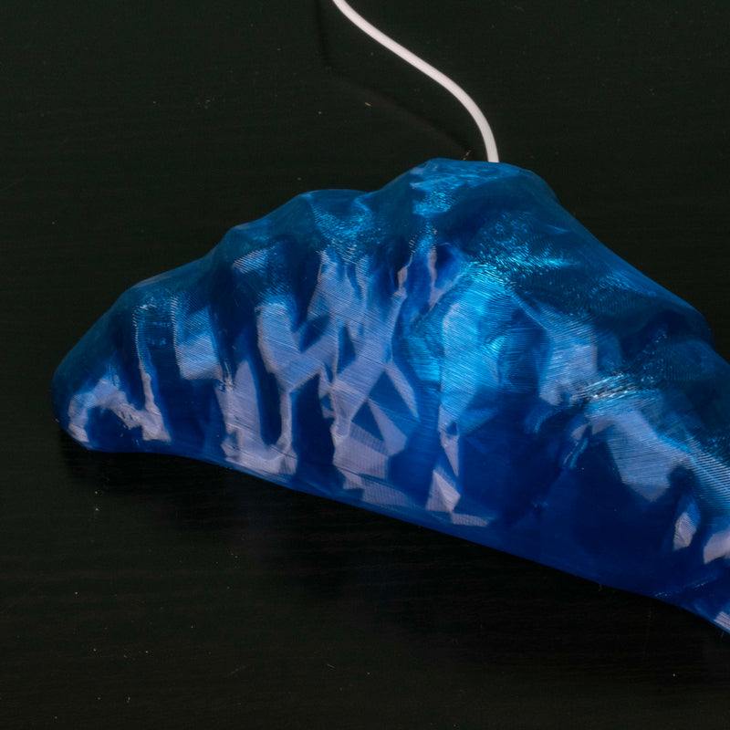 Close up of blue croissant lamp on a black background