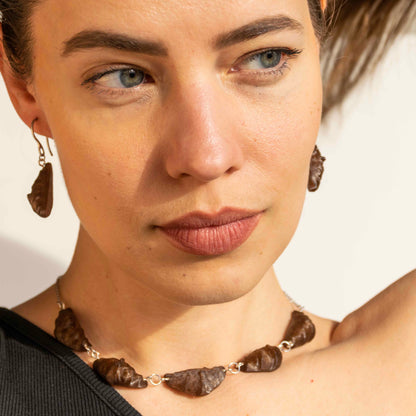 cute, statement collar necklace. silver stainless steal. coffee brown color. croissant shaped. sustainable locally made nacklace